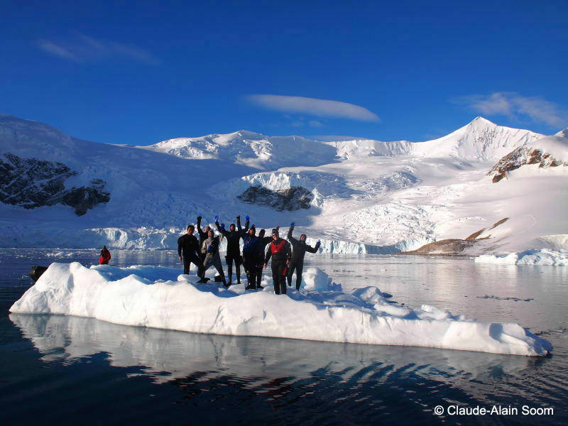 un groupe de plongeur debout sur un iceberg