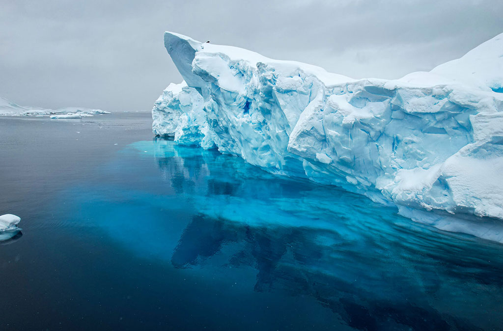un iceberg flotte dans l'eau on voit sa partie immergée